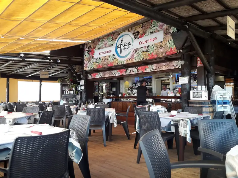 Terraza cubierta y barra del Chiringuito África Beach, con las mesas preparadas
